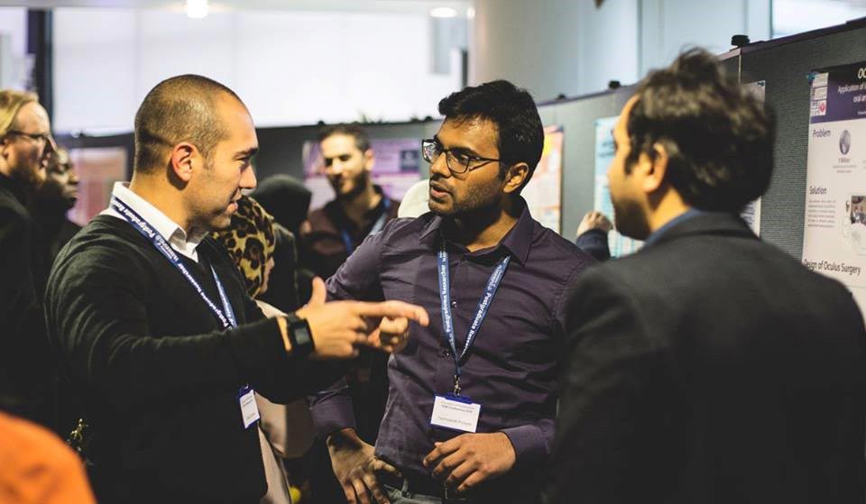 Picture of three people chatting at a conference.